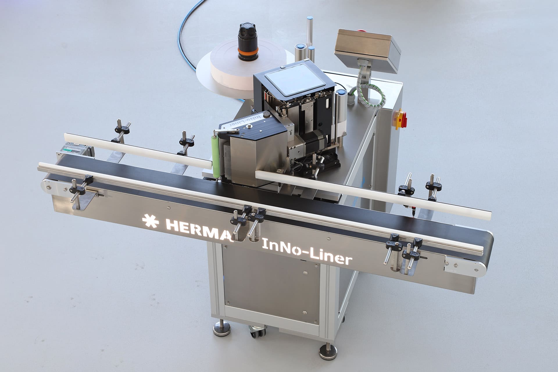 Een etiketteermachine met een transportband, uitgerust met een scherm en verschillende bedieningspanelen.