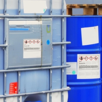 Gevarenstoffen- en gevaarlijke goederenetiketten: Gevarenstoffenetiketten op chemische containers in de buitenlucht