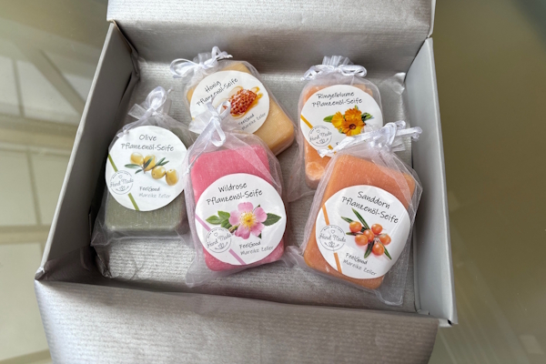 Etsy-zeepetiketten: in een grijze doos zitten 5 natuurlijke zeepjes, verpakt in zijden zakjes. De zeepetiketten zijn voorzien van het Etsy-verkoperslogo en een beschrijving van de inhoud.