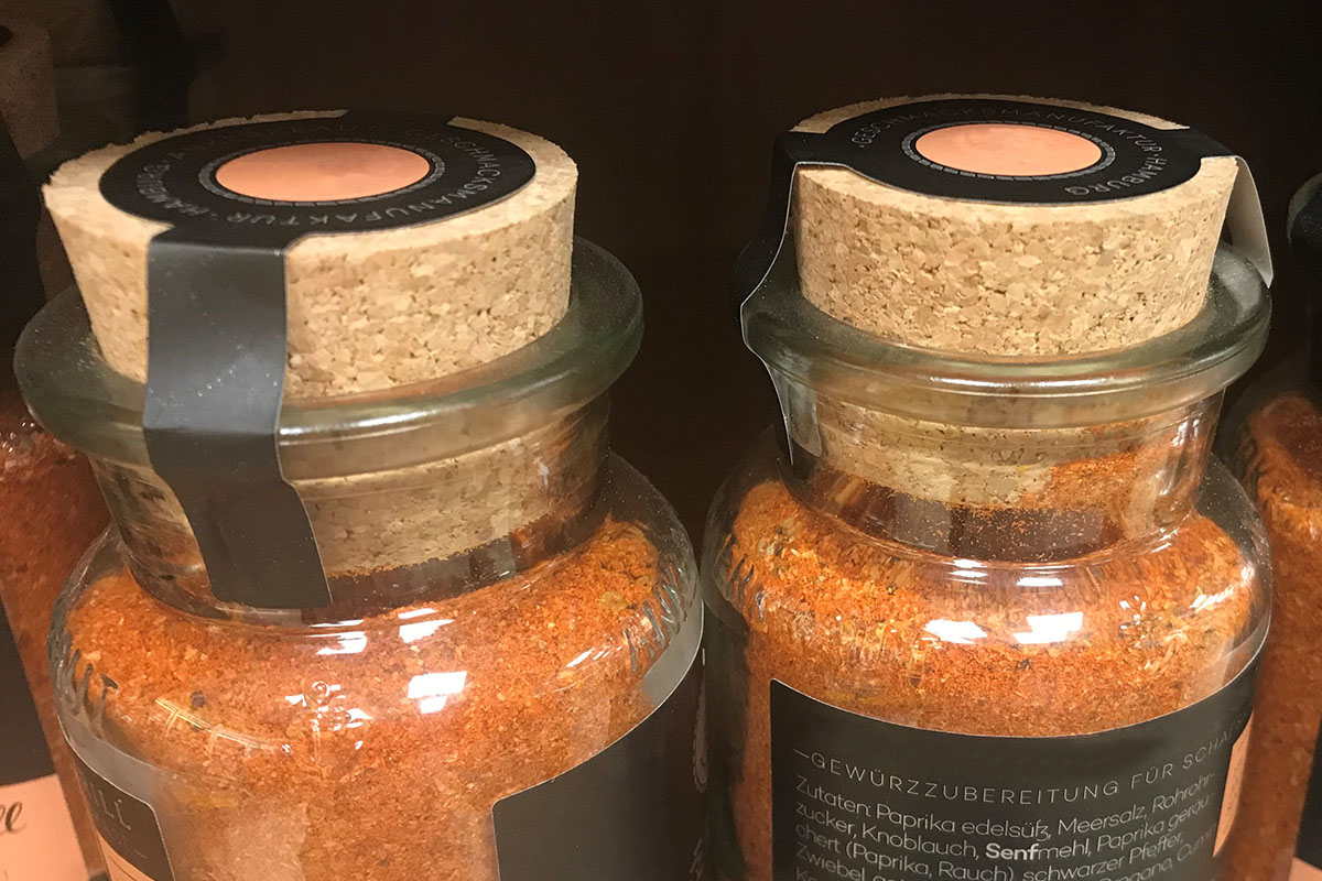 Translation: "Oplossingen Voedsel: Twee-in-één product- en sluitetiket, speciale vorm met zijflappen, full-color bedrukt op kurken deksel (specerijpot)