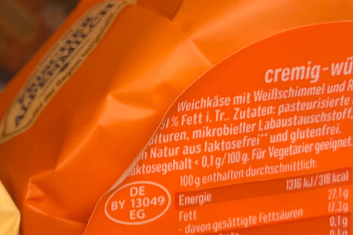 Translation: "Oplossingen Voedsel: Twee-in-één product- en sluitetiket, kleurig voorbedrukt, achteraf thermotransferbedrukt met inhoud, MHC, barcode, op kaasverpakking.