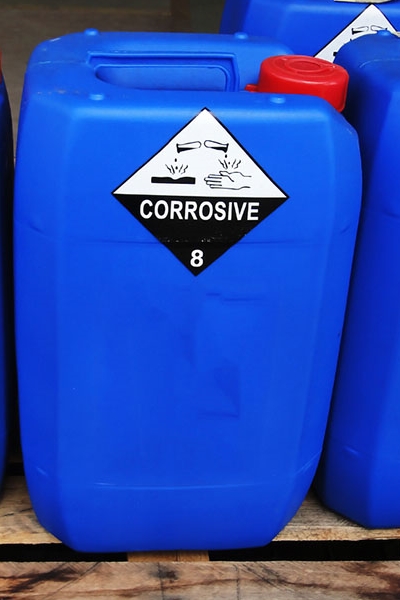 Gevarenstoffen- en gevaarlijke goederenlabels: Gevaarlijke goederenlabels op blauwe kunststof jerrycans in de chemische sector.