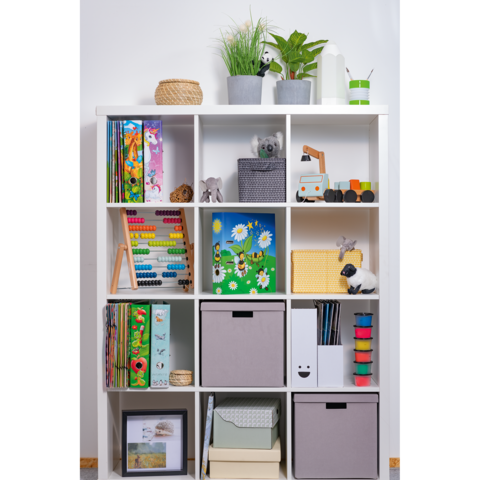 Regal mit verschiedenen Fächern, gefüllt mit Büchern, Spielzeug, Pflanzen und Aufbewahrungsboxen in neutralen Farben.