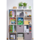 Regal mit verschiedenen Fächern, gefüllt mit Büchern, Spielzeug, Pflanzen und Aufbewahrungsboxen in neutralen Farben.