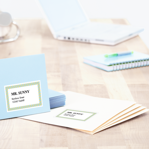 Ordner mit beschrifteten Fächern für eingehende und ausgehende Dokumente, daneben ein Stift und mehrere Umschläge mit Adressen.