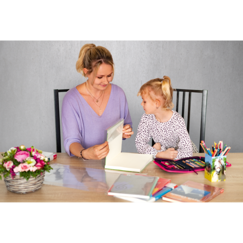 Eine Frau und ein kleines Mädchen sitzen an einem Tisch, während sie gemeinsam an einem kreativen Projekt arbeiten. Bunte Stifte und ein Blumenarrangement sind sichtbar.