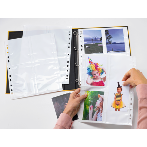 Ein Fotoalbum mit mehreren leeren und gefüllten Taschen, in denen Bilder von Kindern in bunten Kostümen aufbewahrt werden.