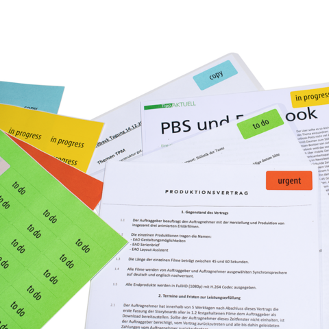Meerdere documenten met verschillende gekleurde post-its, waaronder een productiecontract en aantekeningen over onderwerpen zoals PBS en Facebook.