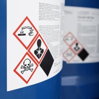 Gevarenstoffen- en gevaarlijke goederenetiketten: Gevarenstoffetiket met 3 gevarensymbolen op blauwe blik.