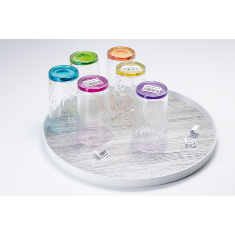 Fünf bunte Gläser mit verschiedenen Deckeln auf einem runden Tablett. Die Gläser sind transparent und haben unterschiedliche Muster.