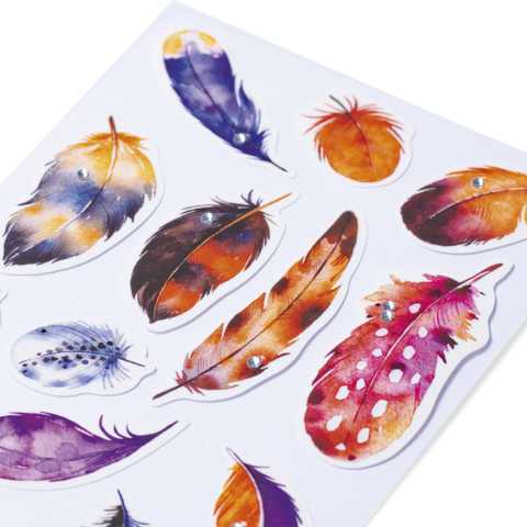 Bunte Federn in verschiedenen Formen und Farben, einige mit Glitzersteinen verziert, auf einem weißen Hintergrund angeordnet.