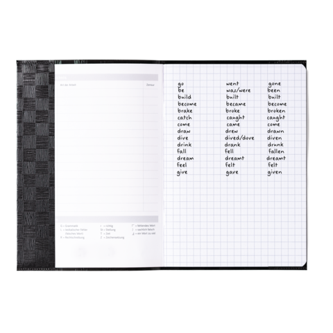 Ein offenes Notizbuch mit einer Liste unregelmäßiger Verben in englischer Sprache, einschließlich ihrer Grundform und Vergangenheitsformen.