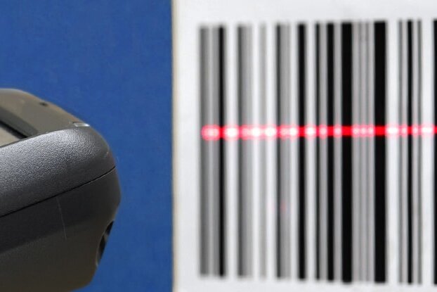Hand met scanner bij het scannen van een barcode-etiket, liggend formaat