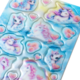 Bunte Aufkleber mit Einhörnern, Herzen und Wolken auf einem blauen Hintergrund.