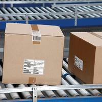 Verzendlabel op bruine dozen, op de transportband in de logistiek.