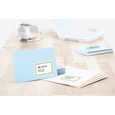 Blaue Karte mit dem Namen "MR. SUNNY" und Adresse, daneben mehrere beige Umschläge und ein Notizbuch auf einem Holztisch.