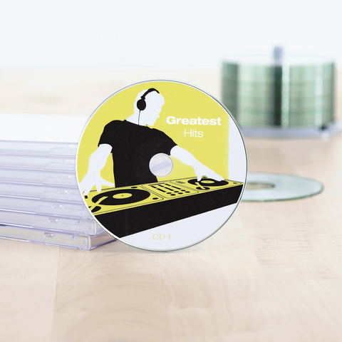 CD met de titel 'Greatest Hits' en een DJ-design, omringd door doorzichtige CD-hoesjes op een tafel.