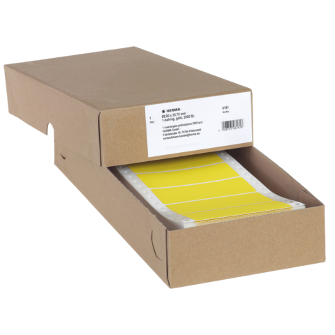 Eine braune Kartonbox mit gelben Etiketten, die teilweise herausgezogen sind. Auf der Box befindet sich ein Etikett mit Produktinformationen.