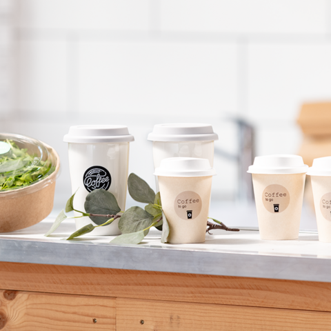 Eine Person hält ein beschriftetes Kuvert mit dem Namen "Michael Gerd" und einer Position. Im Hintergrund sind weitere Kuverts und Etiketten sichtbar.