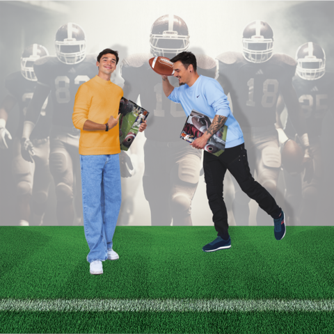 Zwei junge Männer stehen auf einem Fußballfeld. Einer hält einen Football, der andere zeigt Daumen hoch und hält Zeitschriften. Im Hintergrund sind Fußballspieler zu sehen.