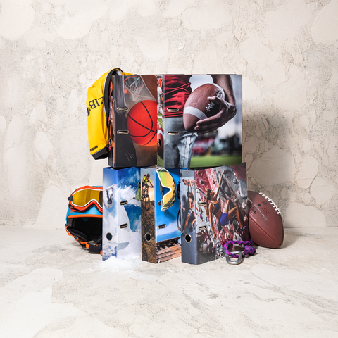 Sportliche Ordner mit verschiedenen Sportmotiven, ein gelber Rucksack, ein American Football, eine Skibrille und Kletterausrüstung.
