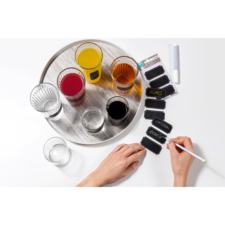 Ein Tablett mit verschiedenen Getränken in Gläsern und einer Hand, die mit einem Stift auf einem Etikett schreibt.