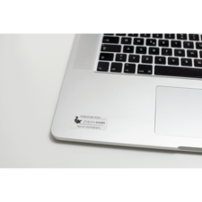 Ein Laptop mit einer Tastatur und einem Aufkleber, der "EIGENTUM VON paperswan NICHT ENTFERNEN" zeigt.