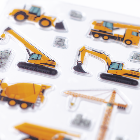 Bunte Aufkleber von Baumaschinen, darunter Bagger, Kran und Betonmischer, auf einem weißen Hintergrund.