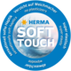 Runder Aufkleber mit dem Text "HERMA SOFT TOUCH", der auf weiche Haptik, Elastizität und den Verzicht auf Weichmacher hinweist.
