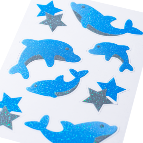 Blau glitterende stickers in de vorm van dolfijnen en sterren op een witte achtergrond.